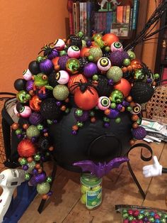 an arrangement of halloween decorations on top of a black ball with eyes and mouthballs