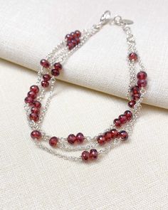 Three strands of microfaceted garnets and sleek rolo chain make an elegant statement. Lobster clasp and extender chain allow for an adjustable fit. Length: 7.5 inches plus 1 inch extender Materials: garnet gemstone, sterling silver Jewelry pouch and gift box included. Elegant Multi-strand Faceted Beads Bracelets, Elegant Multi-strand Beaded Bracelets With Faceted Beads, Elegant Multi-strand Bracelet With Faceted Beads, Elegant Multi-strand Silver Beads Bracelet, Elegant Multi-strand Polished Beaded Bracelets, Elegant Garnet Jewelry With Polished Beads, Elegant Sterling Silver Beaded Bracelet With Faceted Beads, Elegant Multi-strand Beaded Chain Bracelets, Elegant Multi-strand Beaded Bracelets For Gifts