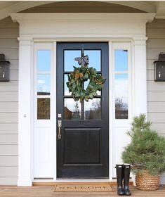 a black front door with a wreath on it