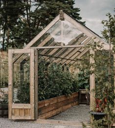 a wooden greenhouse with plants growing inside