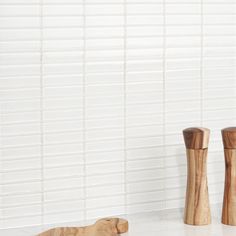 two wooden salt and pepper shakers sitting on a counter top next to each other