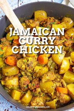 jamaican curry chicken in a pan with a wooden spoon