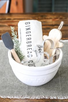 a white bowl filled with kitchen utensils on top of a cloth covered table