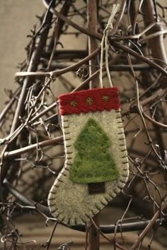 an ornament hanging from a tree branch with a christmas stocking on it