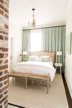 a bedroom with brick walls and white bedding