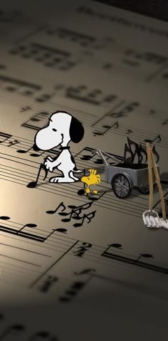 a dog is sitting on top of sheet music next to a toy car and musical notes