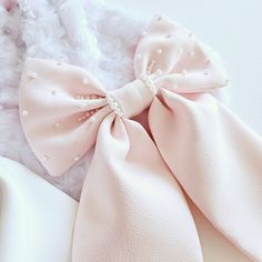 Bespoke large bow in pink satin .  Hand beaded pearl bow tails for a soft sparkle and a touch of elegance. Size: 9 inches. Materials: Satin , pearl beads Finish: Alligator clip. Pita Ideas, Bow Birthday, Pearl Bow, Beautiful Pakistani Dresses, Satin Roses, Aesthetic People, Fabric Bows, Large Bow, Satin Bow