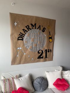 a wall hanging on the side of a bed with pillows and pillow cases in front of it