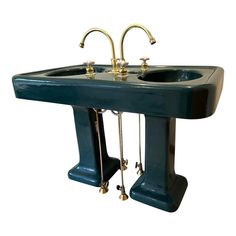 a blue sink with two brass faucets on each side and an attached soap dispenser