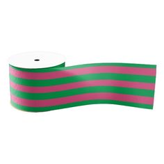 a roll of pink and green striped ribbon on a white background with a black stripe