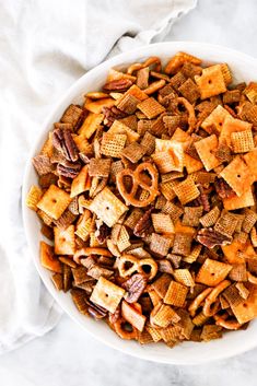 a bowl filled with cheetos and nuts on top of a white table cloth