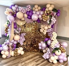 the balloon arch is decorated with purple, white and gold balloons