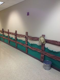 an empty room with a wooden fence and buckets on the floor next to it