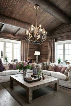 a living room filled with furniture and a chandelier hanging over the top of it