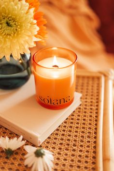 an orange candle sitting on top of a book