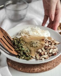 a plate with food on it and a person holding a fork over the top of it