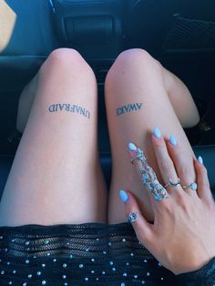 two women with tattoos on their legs sitting in the back seat of a car together