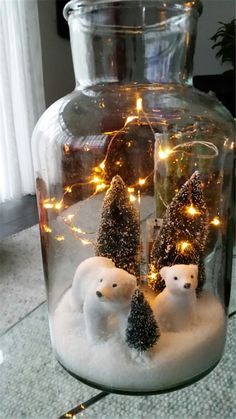 two snowmen in a glass jar with lights