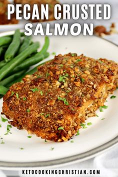 a piece of breaded salmon on a plate with green beans