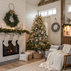 a living room with a christmas tree in the corner and stockings hanging on the fireplace