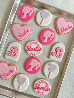 decorated cookies in the shape of heart and woman's names on a baking sheet