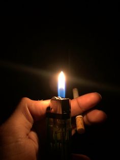 a person holding a lighter in their hand with the light on it's side