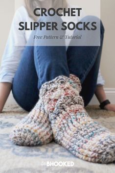 a woman sitting on the floor with her legs crossed and wearing crochet slippers