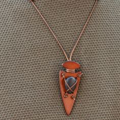 a necklace with a boat shaped pendant hanging from it's side