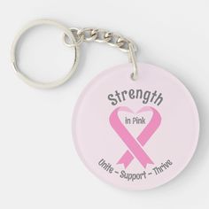 a pink ribbon keychain with the words strength in pink and a heart on it