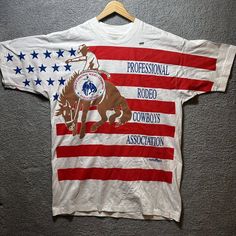 Vintage 90s America Professional Rodeo Cowboy T Shirt Flag Aop Xl Vtg Western. Measurements : 23.5 X 34” Rodeo Cowboy, American Flag Shirt, Flag Shirt, Fruit Of The Loom, The Loom, Rodeo, American Flag, Loom, Vintage 90s