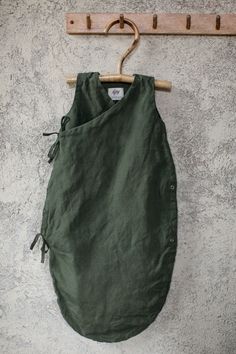 a green bag hanging on a wooden hanger