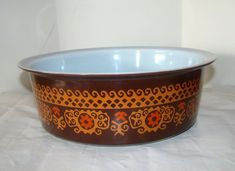 a brown and blue bowl sitting on top of a white table