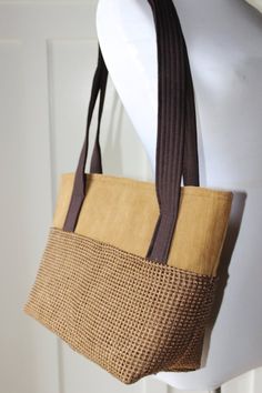 The base of the bag is created with a tan and brown woven/waffle fabric;  the top is a tan faux suede fabric. Chocolate linen lines this bag that features a magnetic snap closure.  Linen straps comfortably fit the shoulder.  Bag is fully lined and interfaced with a stiff interfacing for structure and stability.L-12"W-5"H-10"Strap Length-28"Drop from Shoulder-11" Brown Crochet Shoulder Bag For On-the-go, Brown Rectangular Crochet Bag For On-the-go, Brown Crochet Bag With Adjustable Strap For Shopping, Brown Crochet Rectangular Bag For On-the-go, Brown Crochet Shopping Bag With Adjustable Strap, Brown Crochet Bag With Removable Pouch For Everyday Use, Brown Crochet Bag With Adjustable Strap For Everyday Use, Everyday Brown Woven Bag, Everyday Brown Crochet Bag With Handles