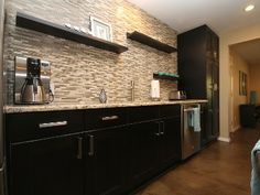 a kitchen with black cabinets and stainless steel appliances