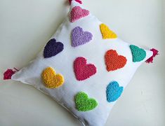 a decorative pillow with multicolored hearts on it