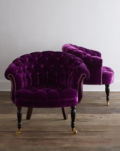 two purple chairs sitting next to each other on top of a hard wood floor in front of a white wall