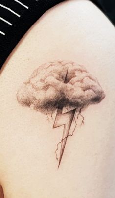 a woman's stomach with a tattoo of a cloud and lightning