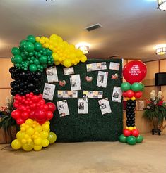 an arrangement of balloons and pictures on a wall in a room with carpeted flooring