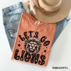 Show your Lion pride on game day in this cute retro Let's Go Tigers t-shirt!  *Please message us for youth sizes.* COMFORT COLORS DETAILS: .: Soft-washed, garment-dyed fabric  .: Double-needle stitching throughout  .: 100% ring-spun cotton .: Medium fabric (6.1 oz/yd² (206.8 g/m .: Relaxed fit .: Sewn-in twill label CARE INSTRUCTIONS: .: Machine wash cold; do not bleach. Dry on low heat or lay flat to dry; do not dry clean. SIZING .: This is a relaxed fit shirt. For a fitted look consider sizing Mascot Shirts, Football Merch, Lion Games, Lion Mascot, Lions Football, Lion Shirt, Lion Pride, Lion Tshirt, Tiger T Shirt