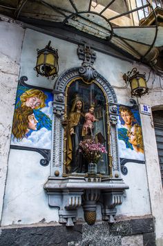 an ornate window with paintings on the side of it