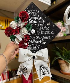 a person holding a graduation cap with flowers on it