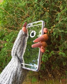 someone holding up their cell phone to take a selfie with an apple logo on it