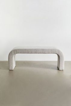 a white bench sitting on top of a cement floor