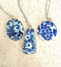 three necklaces with blue and white designs on them