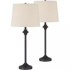 pair of black metal table lamps with white linen shades on each lamp and one light off