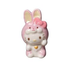 a hello kitty figurine sitting on top of a white surface with a pink bow