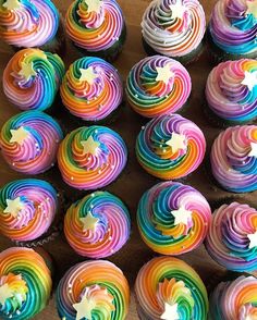 there are many cupcakes with rainbow frosting on the top one is star shaped