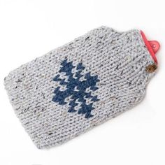 a knitted bag with blue and white designs on the front, sitting on a white surface