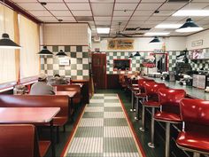 a restaurant with checkered flooring and red chairs