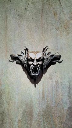 the face of an evil demon is shown in this artistic photo, which appears to be made out of concrete